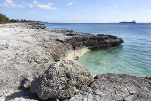 costa rochosa da ilha grand bahama e navio industrial foto