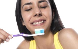 mulher jovem feliz com dentes saudáveis, segurando uma escova de dentes foto