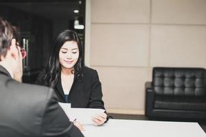 bela jovem candidata asiática se apresenta ao entrevistador com um grande sorriso por conseguir emprego no escritório foto