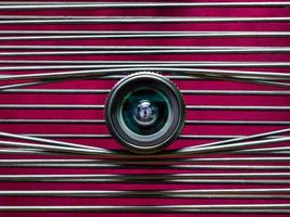 uma lente de câmera de um olho contra um fundo roxo foto