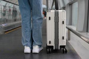 pé de mulher close-up andando com mala, check-in no aeroporto internacional, viagens de férias e conceito de transporte foto