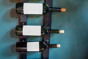 garrafas de vinho alinhadas na prateleira o fundo é verde escuro. foco suave e seletivo.