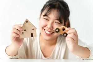 comprador de mulher asiática escolhendo entre comprar casa nova ou carro. planejando comprar casa e carro. foto