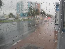 chuva na estrada dos Emirados Árabes Unidos bela vista e área de estar entregador impondo em bebê chuvoso jogando grama de cadeira em chuvoso, tráfego continua na estrada em dia chuvoso foto