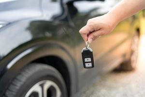 um funcionário de uma empresa de aluguel de carros turísticos apresenta as chaves do carro com um test drive. bom serviço antes de concordar com um contrato de locação ou compra. foto