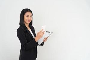 empresária asiática sorrindo e segurando o smartphone. linda mulher asiática em pé com os braços cruzados. retratos femininos. funcionário do banco, contador, administração, oficial foto