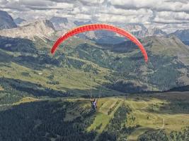 parapente voando no panorama das dolomitas foto