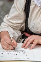 mãos escrevendo uma carta com uma pluma foto