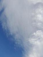 lindas nuvens brancas sobre fundo de céu azul profundo. elegante imagem de céu azul à luz do dia. grandes nuvens fofas e brilhantes cobrem todo o céu azul. foto