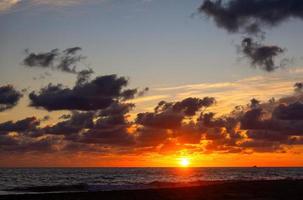 pôr do sol na praia com lindas nuvens foto