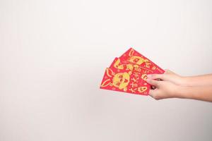 mulher segurando o envelope vermelho chinês com coelho dourado e palavra de bênção, presente de dinheiro para o feliz feriado do ano novo lunar. frase chinesa significa felicidade, saudável, sortudo e rico foto