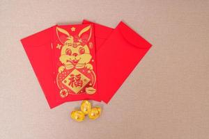 envelope vermelho chinês com barras de ouro, presente de dinheiro para o feliz feriado do ano novo lunar. frase chinesa significa felicidade, saudável, sortudo e rico foto