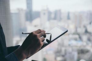 empresário trabalhando com tablet com o fundo da cidade foto