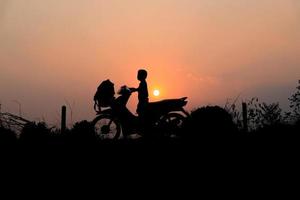 silhueta de menino em uma motocicleta foto