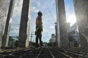 trabalhador usando arnês de segurança de equipamentos e linha de segurança trabalhando em local alto trabalho em conceitos de canteiro de obras de prédio residencial em construção foto