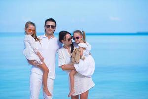 família usando óculos escuros e roupas brancas nas férias de verão foto