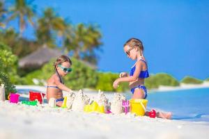 duas meninas construindo um castelo de areia foto