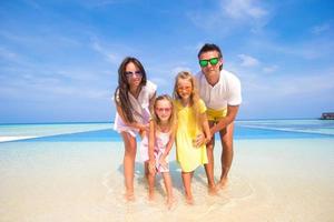 família na água em uma praia tropical foto