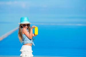 garota segurando protetor solar em uma praia foto