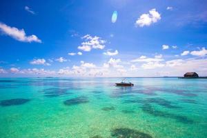 maldivas, sul da ásia, 2020 - barco nas águas azuis do oceano foto