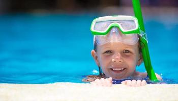 garota em uma piscina com equipamento de snorkel foto