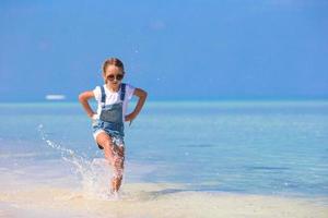 garota correndo na água na praia foto