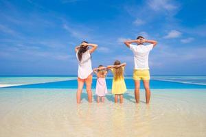 família relaxando em uma praia tropical branca foto