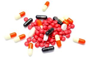 remédio de pílula vermelha e cápsula em fundo branco. foto