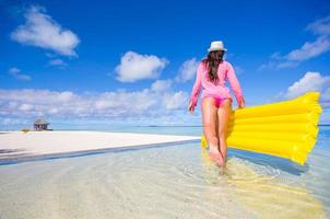 mulher caminhando na água na praia foto