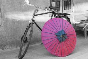 bicicleta preta e branca com guarda-chuva vermelho foto