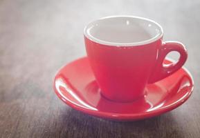 xícara de café vermelha em uma mesa de madeira foto