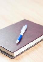 caderno de couro com caneta azul foto