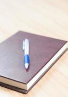 caderno de couro com uma caneta foto