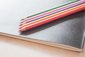 close-up de lápis de cor em um caderno preto foto