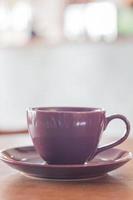 caneca violeta em uma mesa de madeira foto