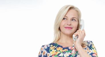 mulher de vestido azul fala emocionalmente ao telefone isolado no fundo branco foto