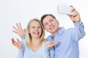 casal feliz tomando selfie com smartphone isolado no branco foto