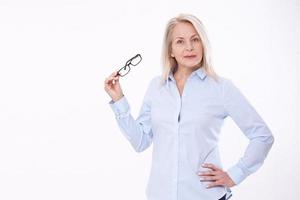 mulher de negócios de meia-idade com óculos na camisa azul isolada no fundo branco foto