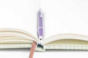 close-up de um caderno e caneta abertos foto