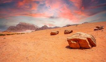 céu vermelho, areias e pedras do deserto de wadi rum, jordânia foto