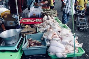 badung, bali - 13 de janeiro de 2023, visto que um vendedor de carne de frango está vendendo carne de frango ao comprador foto