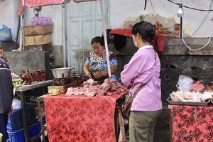 badung bali 13 de janeiro de 2023 um comprador é visto comprando frutas e vegetais frescos em um mercado tradicional em bali foto
