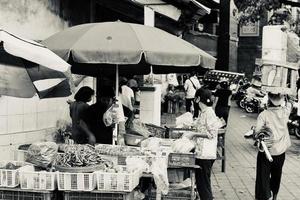 badung, bali - 13 de janeiro de 2023 foto em preto e branco de um vendedor negociando com um comprador no mercado badung kumbasari