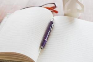 caneta e caderno em uma mesa de madeira foto