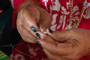 mãos crafting colar de conchas da polinésia foto