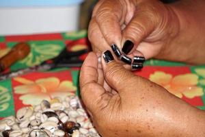 mãos crafting colar de conchas da polinésia foto