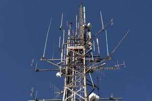 transmitindo grande antena no céu azul foto