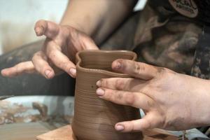 mãos enquanto elabora detalhes de cerâmica de perto foto
