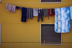 roupas penduradas fora de casa secando ao sol foto