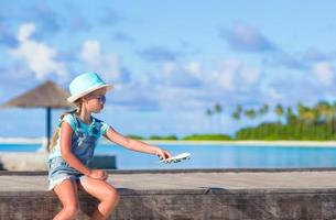 menina brincando com um avião de brinquedo foto